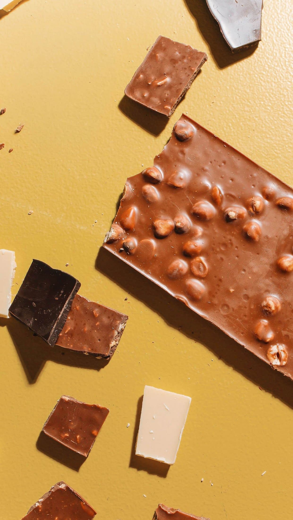 Overhead view of a hazelnut chocolate bar broken into pieces